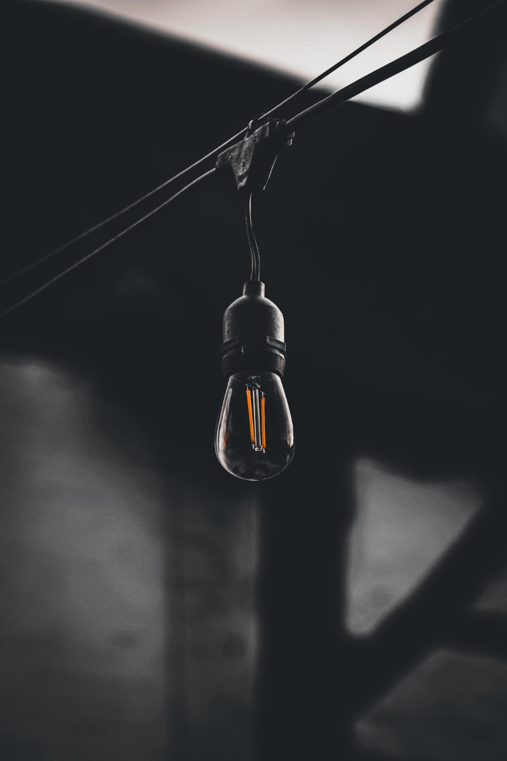 vertical shot lamp hanging wire dark blurry background